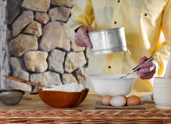 Wheat flour and eggs amid men chef sifting flour for the dough. Concept of rustic kitchen, selective focus. Copy space. Free space for text. black and white photo