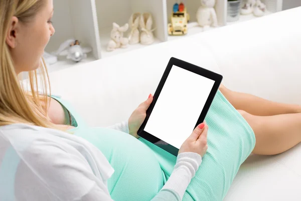 Pregnant woman using blank screen tablet