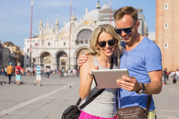 Couple looking at tablet computer while traveling in Venice