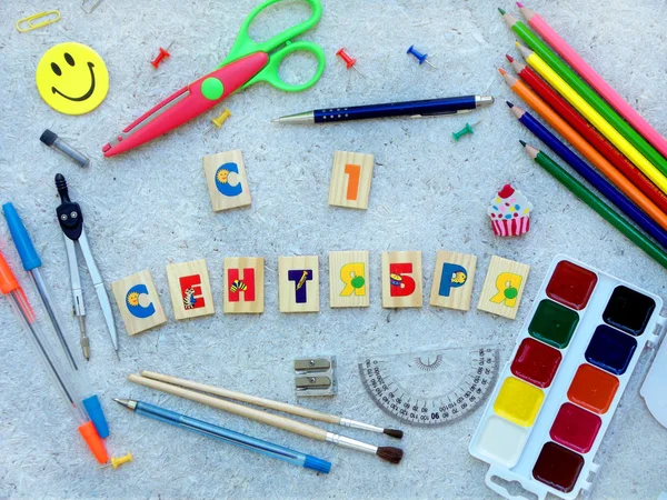 School supplies and  inscription congratulation on September 1 in Russian made up of cubes, showing back to school messageand open day