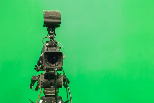Television studio with camera and lights - camera on green screen