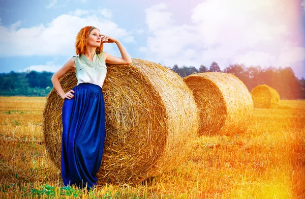 Girl in a field near the haystacks