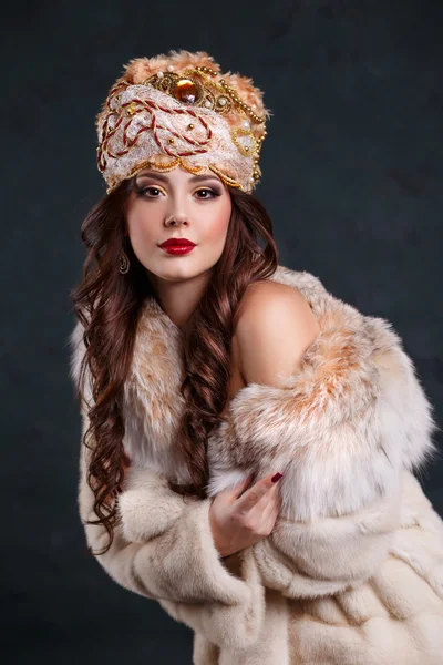 Queen in royal dress. sexy girl in royal hat and fur coat