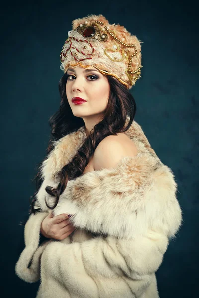 Queen in royal dress. sexy girl in royal hat and fur coat