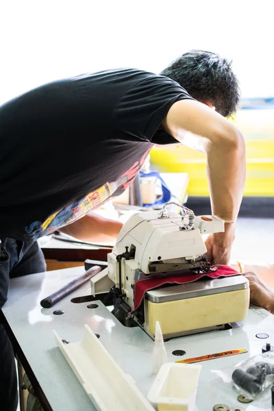 Mechanic repairing industrial sewing machine