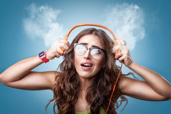 Confused surprised girl in headphones listening to music.