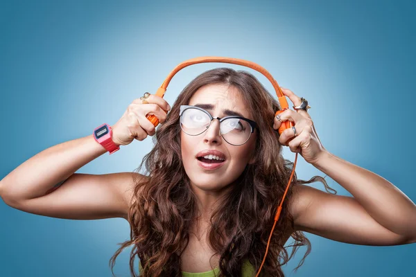 Confused surprised girl  in headphones listening to music.