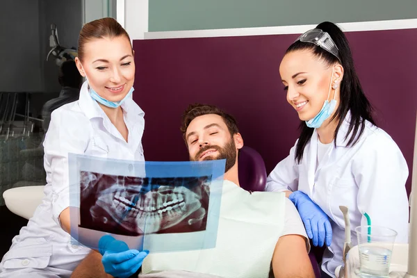 Dentist shows a patient x-ray of teeth.