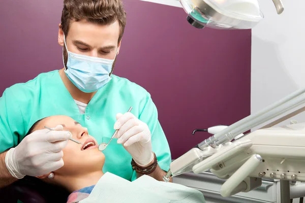 Male dentist examines mouth of woman on the dentist\'s chair