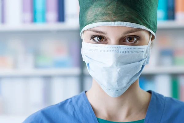 Female surgeon with cap and surgical mask