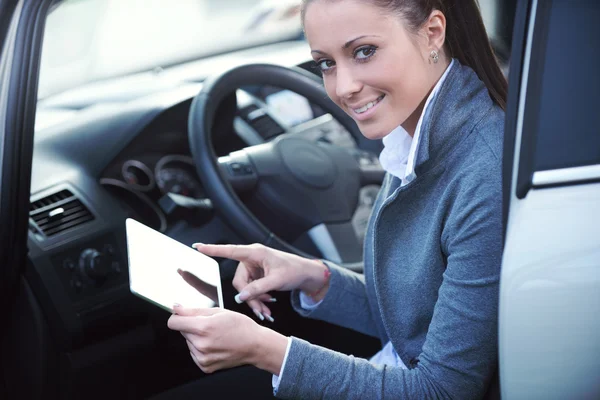 Smiling woman in a car with tablet