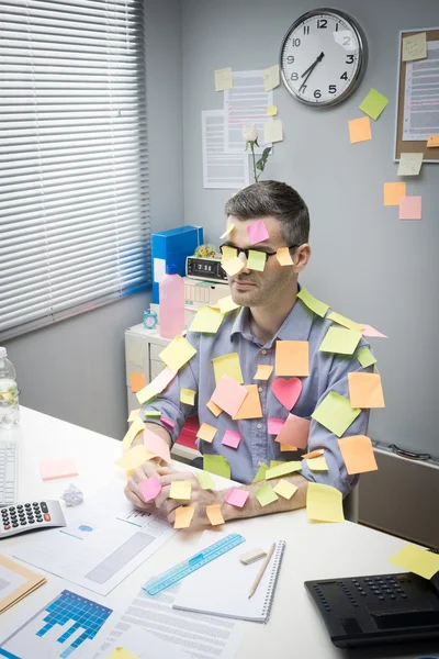 Office worker covered with stick notes