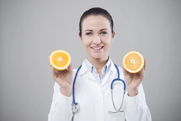 Smiling doctor showing a juicy orange