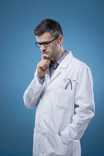 Pensive doctor with hand on chin
