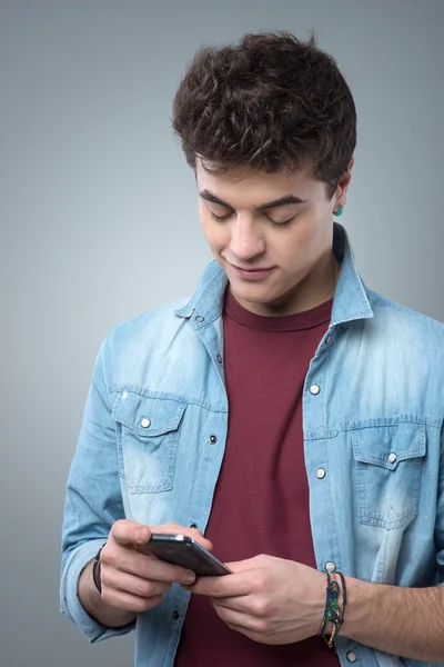 Smiling guy texting with smartphone