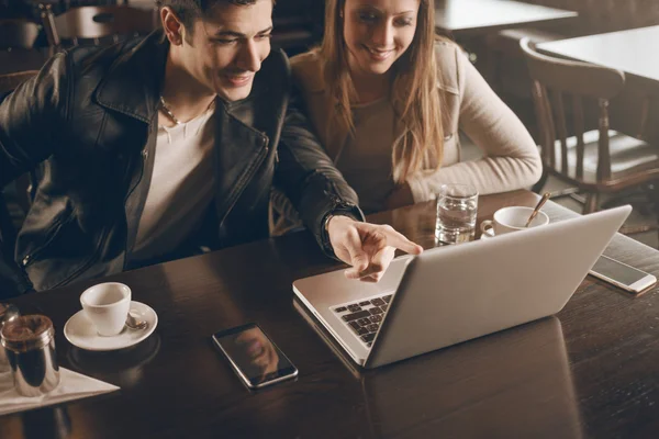 Couple at the bar using a laptop