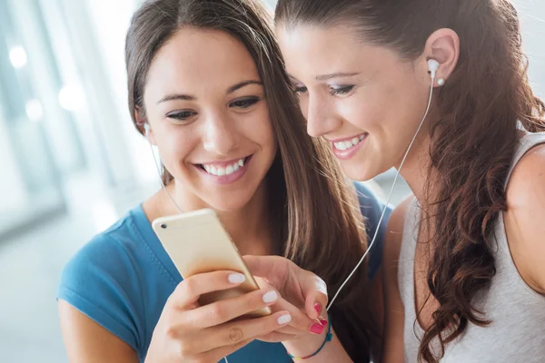 Pretty girls sharing earphones