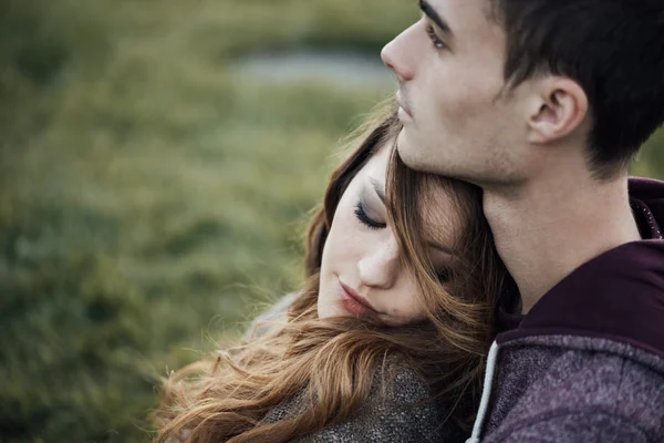 Young loving couple sitting on the grass