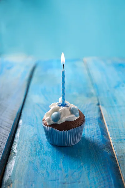 Birthday cupcake over blue background