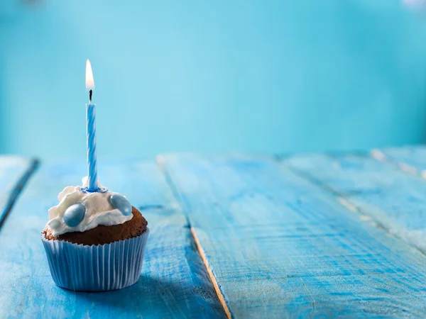 Birthday cupcake over blue background