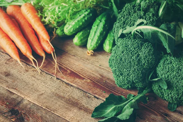 Spring harvest - group of fresh vegetables on wooden background. Toned image