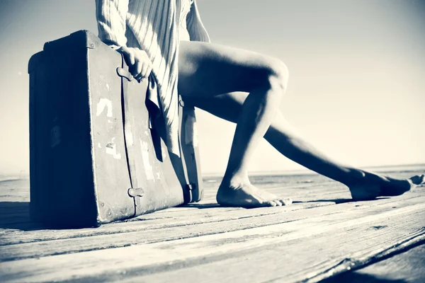 Relaxed woman resting after a long journey with her big suitcase