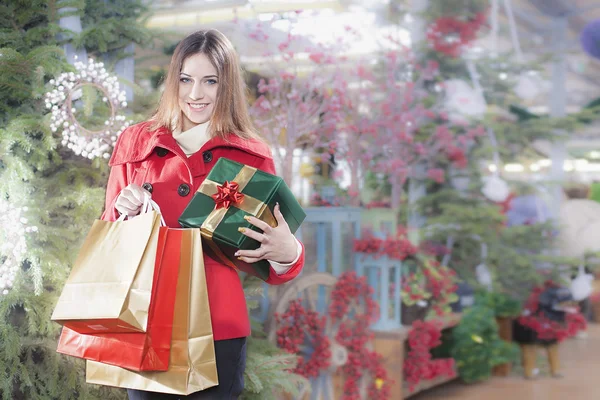 Young woman shows her gift packs inside a Christmas shop