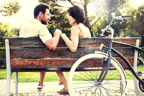 Couple in love sitting together on a bench with bikes