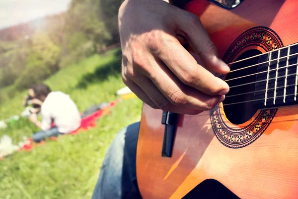 Group of happy friends with guitar having fun outdoor