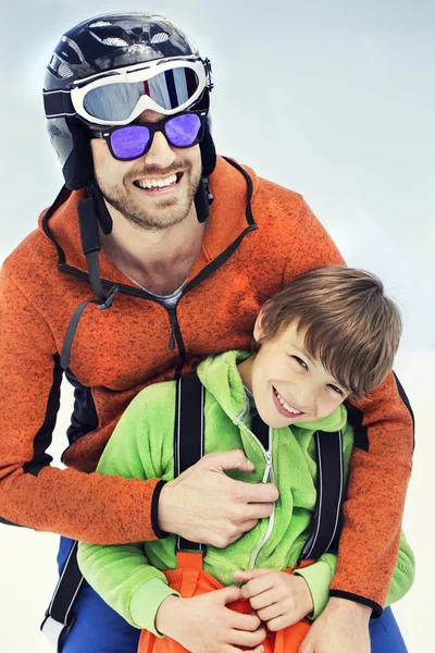 Father hugs his son affectionately in the snow