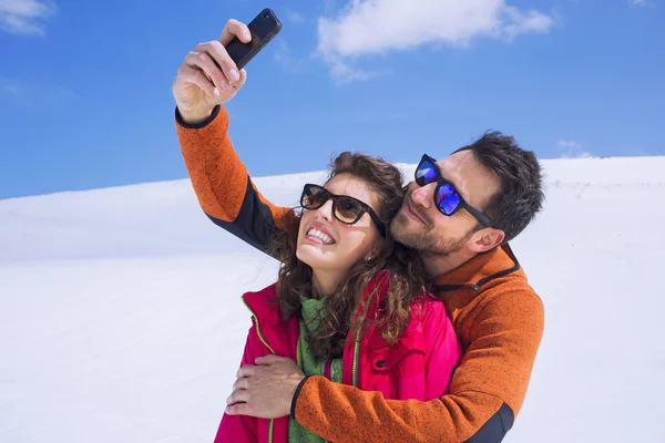 Couple having a selfie on the snow in montain