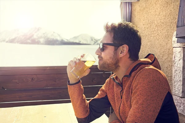 Seated and relaxed man drinking a beer in peace