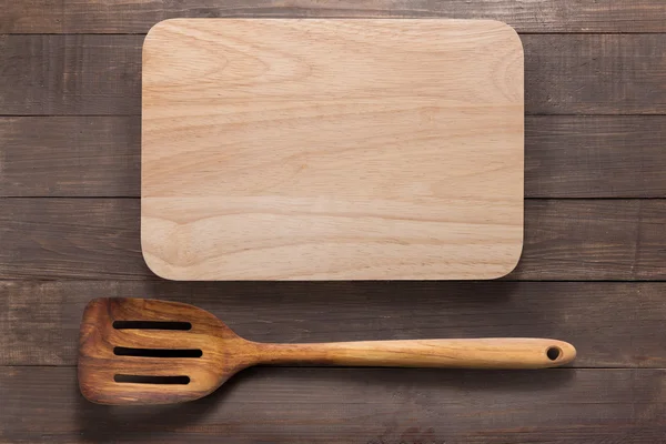 Cutting board and  spatula on the wooden background