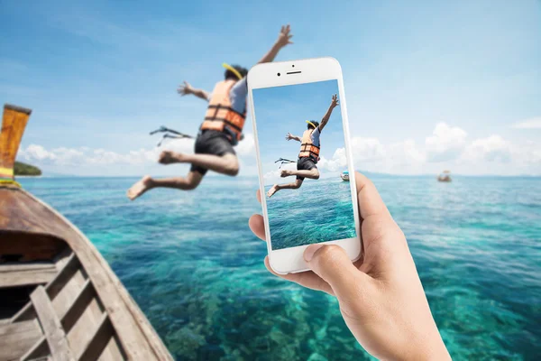 Taking photo of snorkeling divers jump in the water.