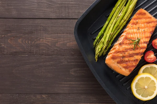 Grilled salmon cooked BBQ on a pan on wooden background