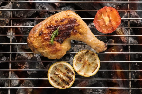 Grilled chicken leg over flames on a barbecue