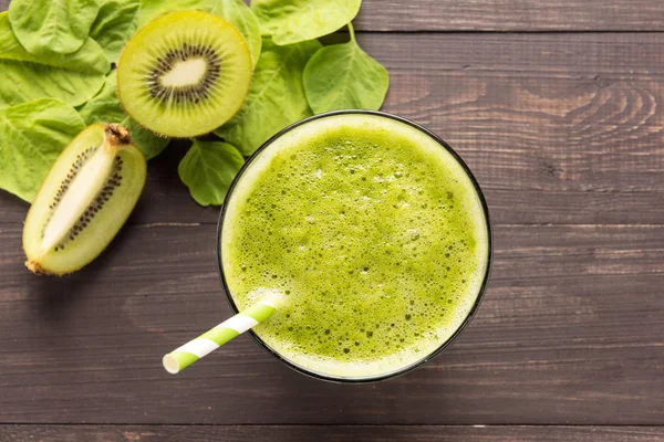 Healthy green smoothie with kiwi on rustic wood background