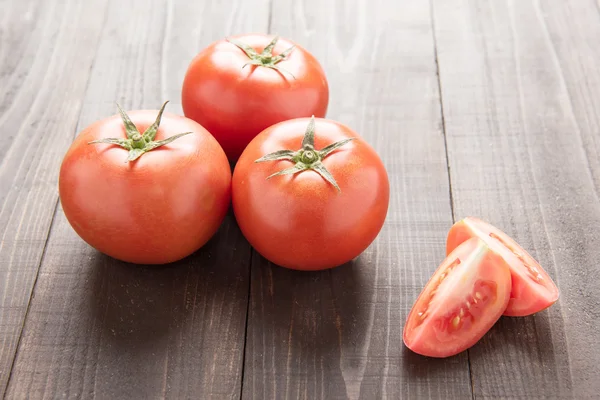 Fresh tomato on the brown wooden background. Top view