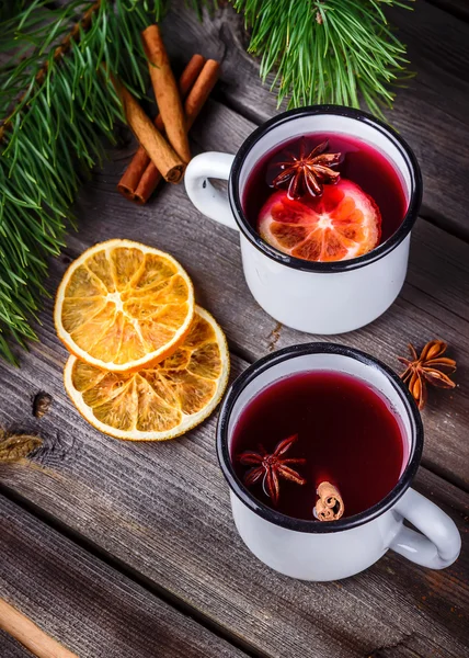 Two mugs of mulled wine on wooden table.
