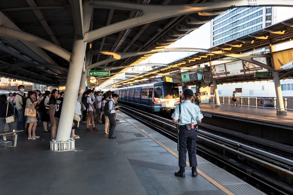 Security guard at BTS public train station watching passenger to ensure safety