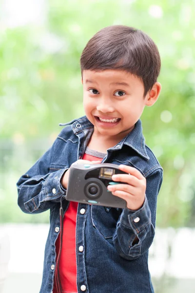 Asian boy with compact camera.