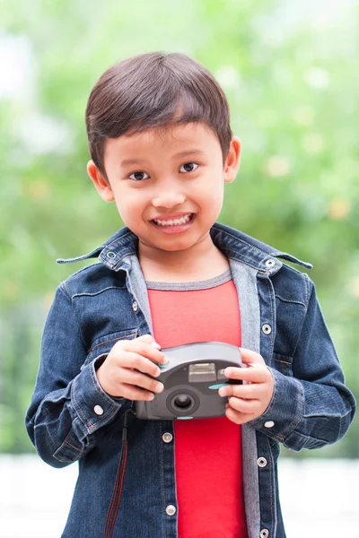 Asian boy with compact camera.