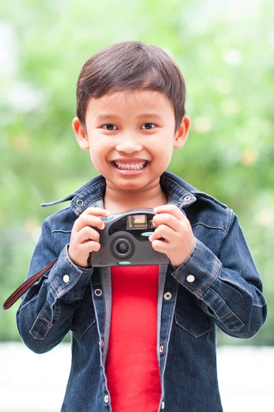 Asian boy with compact camera.