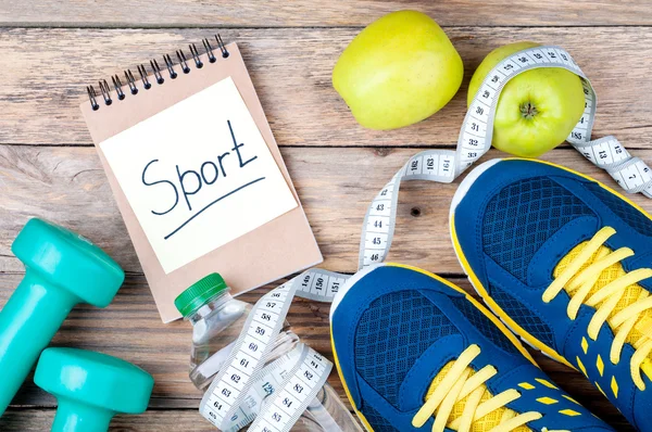 Sport shoes, apples, bottle of water, measuring tape, dumbbells and words 
