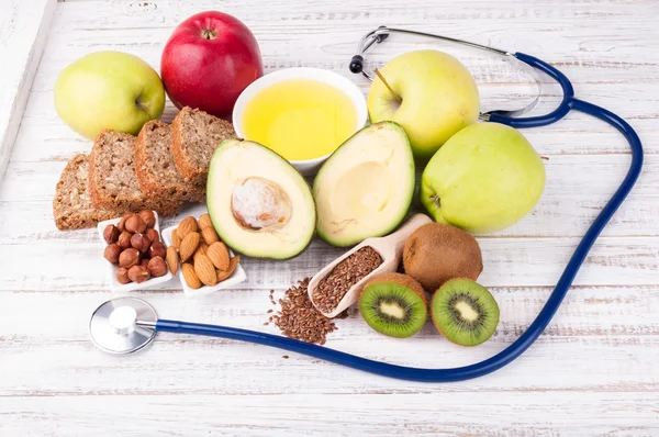 Healthy fats and healthy food that is good for heart, stethoscope on wooden background