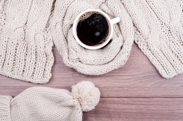 Handmade knitted wool scarf and cap. Winter clothes. Hot coffee