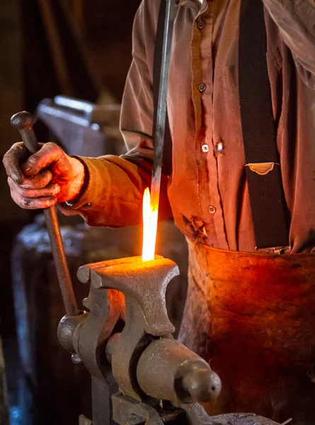 Blacksmith bending a hot metal rod