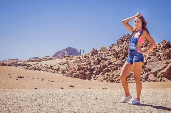 Female model posing in a desert environment and ocean