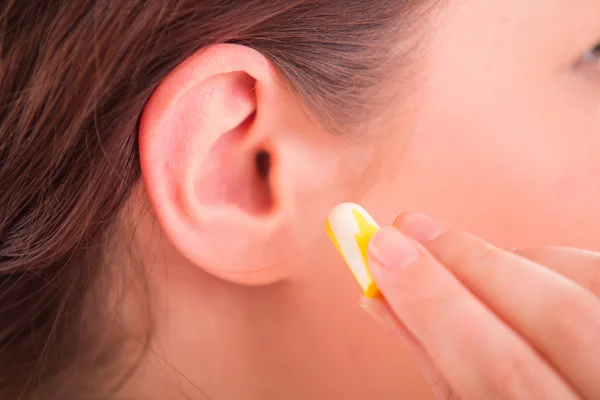 Woman putting earplug into ear