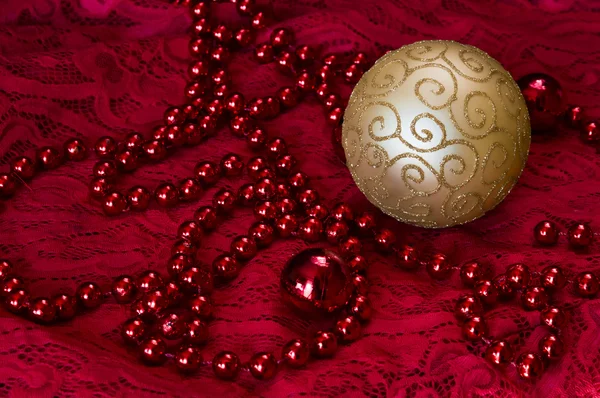 Christmas decorations on a red background Accessories. Gold Ball toy with bright lace.